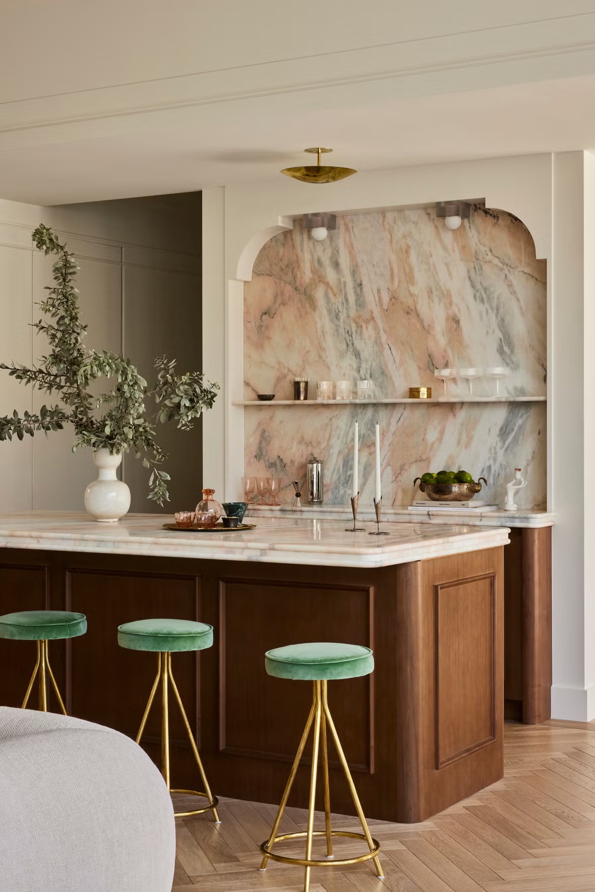 Marble kitchen with a wooden island and green stools